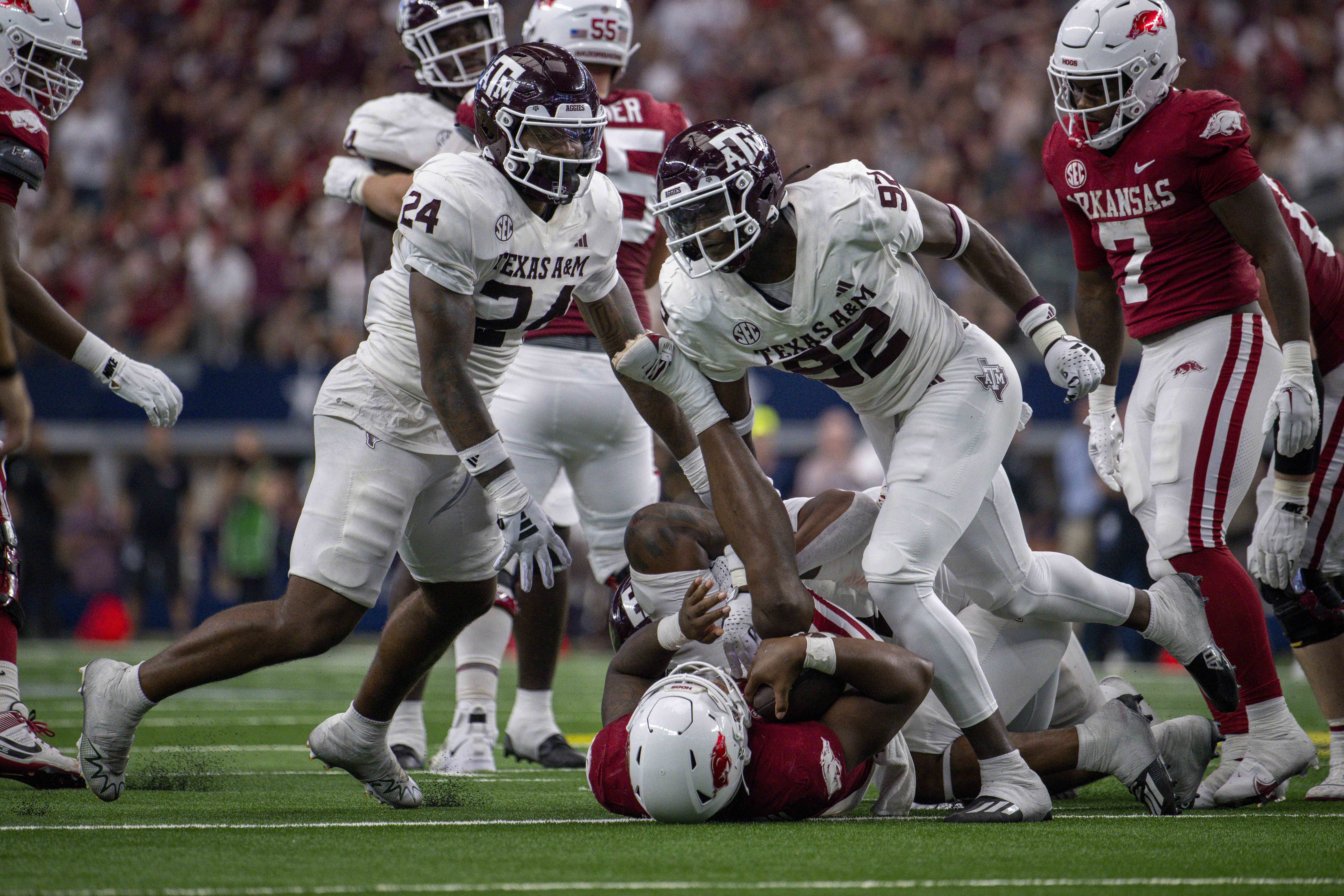 Texas A&M Aggies linebacker Chris Russell Jr. (24) and defensive lineman Malick Sylla (92) celebrate a sack of Arkansas Razorbacks quarterback KJ Jefferson (1) during the second half at AT&T Stadium.